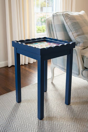 Black needlepoint self finishing table with decorative items in a living room setting