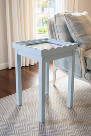 Light Blue needlepoint self finishing table with decorative items in a living room setting