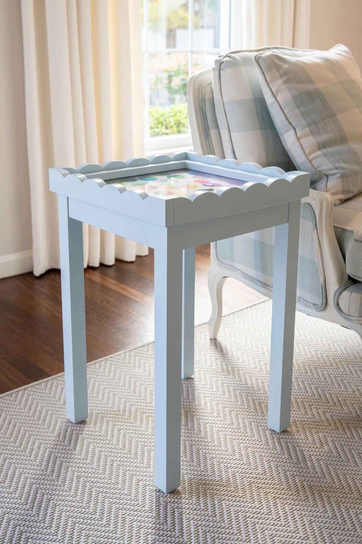 Light Blue needlepoint self finishing table with decorative items in a living room setting